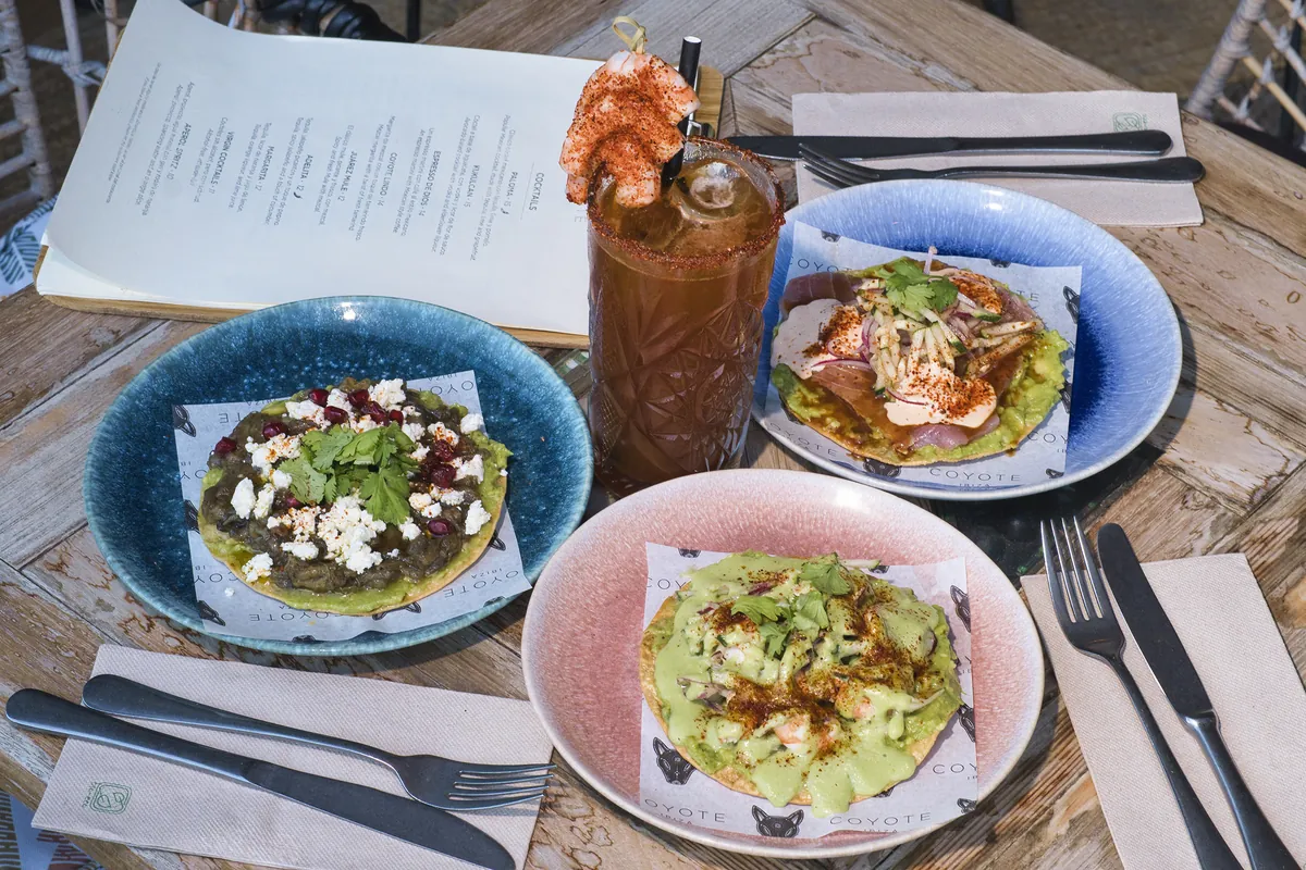 Tavolo con tostadas, una michelada e il menu di Coyote