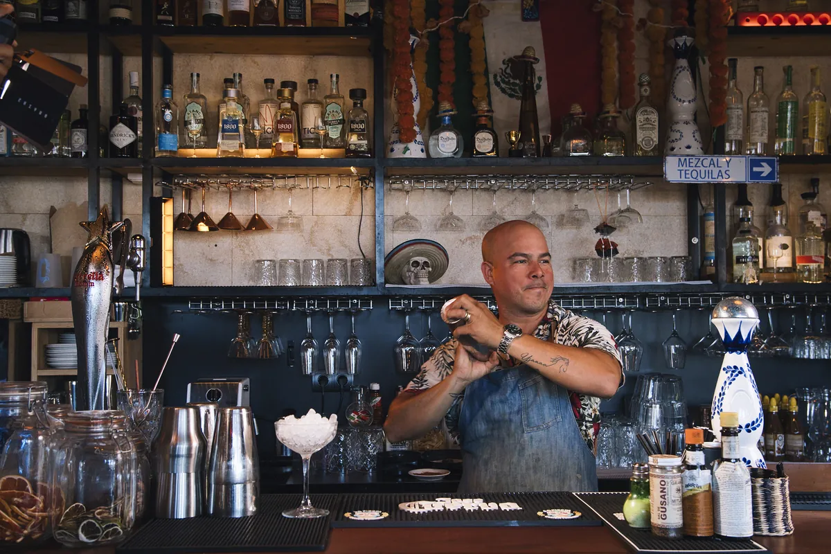 Marco Caropreso prepara un cocktail dietro il bancone di mezcal e tequila